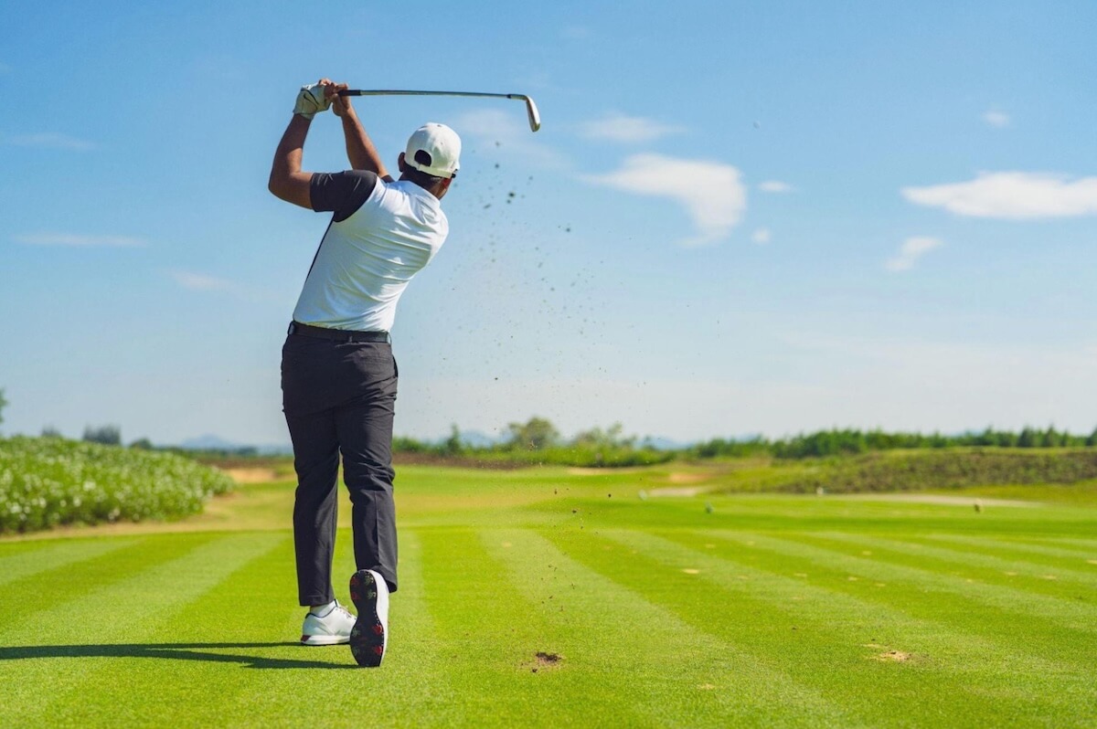 A golfer playing well on a course after learning from a golf instructor.